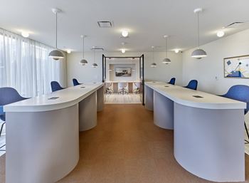 a conference room with blue chairs and white tables